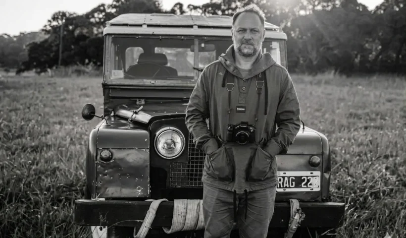 Mariano Larralde fotógrafo de Mar del Plata posando junto con su camara fotografica delante de su Land Rover