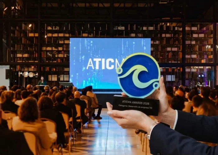 manos sostiene la estutuilla del premio de ATICMA delante del audiotorio en el Paseo Aldrey