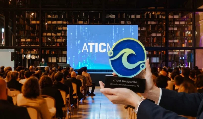 manos sostiene la estutuilla del premio de ATICMA delante del audiotorio en el Paseo Aldrey