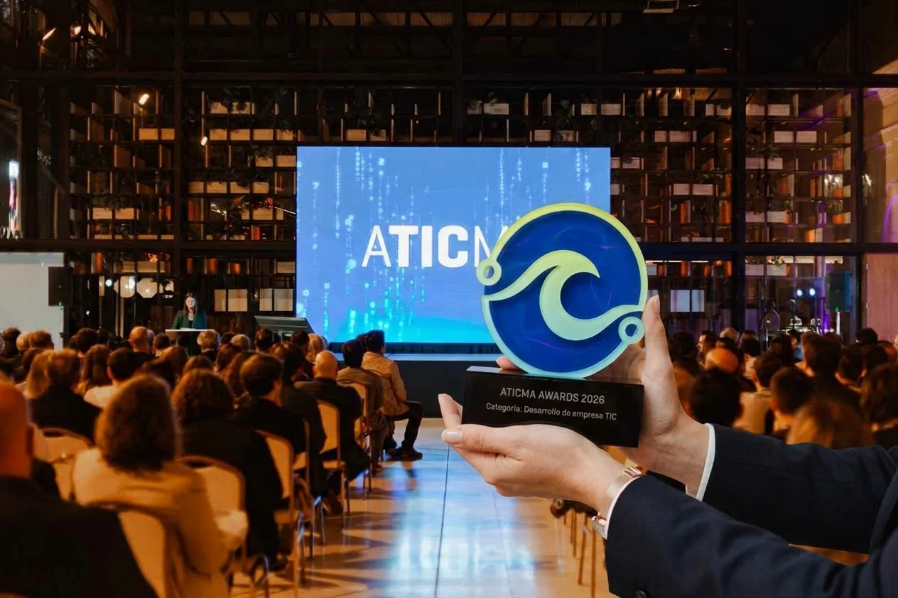 manos sostiene la estutuilla del premio de ATICMA delante del audiotorio en el Paseo Aldrey